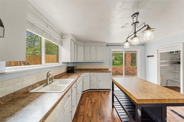 720 N Walnut St, Colorado Springs, CO 80905 - kitchen with dark wood-type flooring, white cabinets, decorative light fixtures, backsplash, and wooden counters