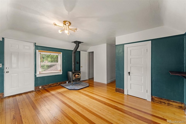 720 N Walnut St, Colorado Springs, CO 80905 - unfurnished living room with light wood-style floors, a wood stove, lofted ceiling, and a chandelier