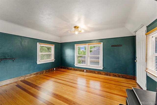 720 N Walnut St, Colorado Springs, CO 80905 - empty room with hardwood / wood-style flooring, a chandelier, healthy amount of natural light, and lofted ceiling