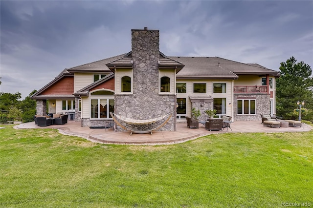 13 Tamarade Dr, Littleton, CO 80127 - back of property with a lawn, stone siding, and an outdoor hangout area