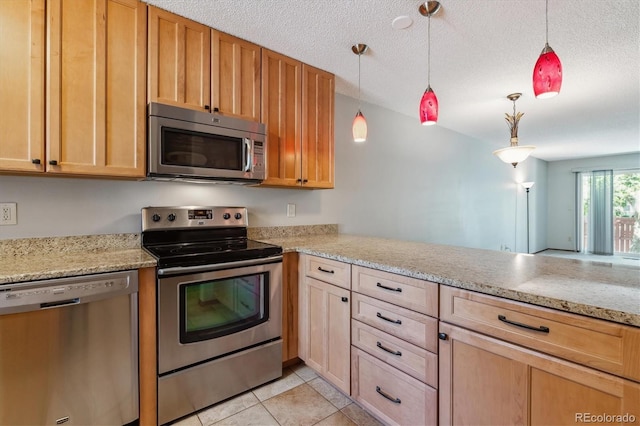 kitchen with light stone counters, a peninsula, light tile patterned flooring, stainless steel appliances, and a textured ceiling