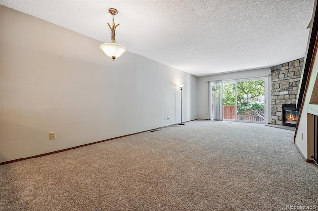 unfurnished living room featuring a fireplace, carpet, baseboards, and a textured ceiling