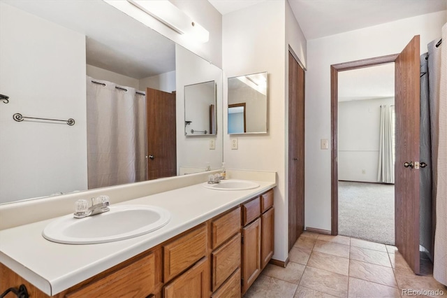 bathroom featuring a sink, baseboards, double vanity, and tile patterned flooring