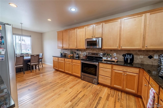 9844 Norfolk St, Commerce City, CO 80022 - kitchen featuring appliances with stainless steel finishes, light wood-style floors, decorative backsplash, recessed lighting, and hanging light fixtures