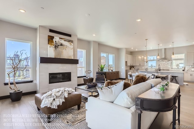 1768 Peak Loop, Broomfield, CO 80023 - living area with light wood-type flooring, plenty of natural light, recessed lighting, and a tile fireplace