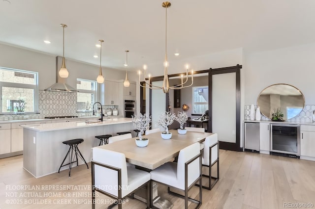 1768 Peak Loop, Broomfield, CO 80023 - dining space featuring wine cooler, a chandelier, light wood-style floors, and recessed lighting