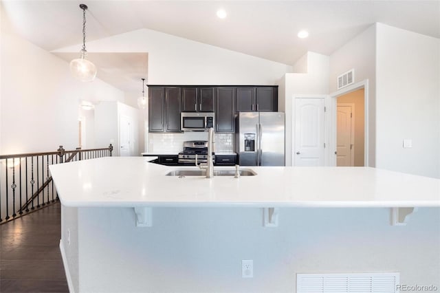 8230 Misty Moon Dr, Colorado Springs, CO 80924 - kitchen featuring appliances with stainless steel finishes, a breakfast bar area, dark wood finished floors, and high vaulted ceiling