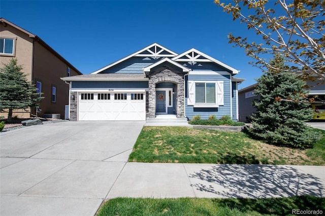 8230 Misty Moon Dr, Colorado Springs, CO 80924 - craftsman-style house featuring stone siding, an attached garage, concrete driveway, and a front lawn
