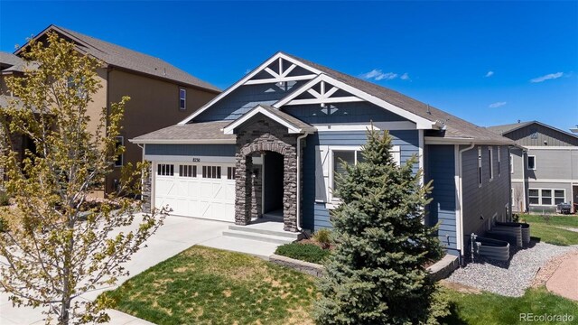 8230 Misty Moon Dr, Colorado Springs, CO 80924 - view of front of home featuring an attached garage, concrete driveway, and stone siding
