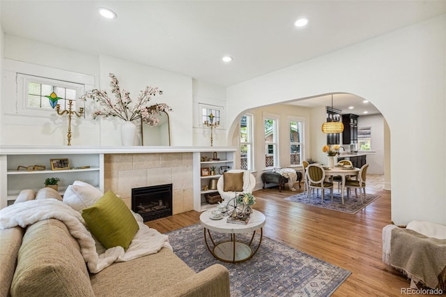2738 W 38th Ave, Denver, CO 80211 - living room featuring arched walkways, a tile fireplace, wood finished floors, and recessed lighting