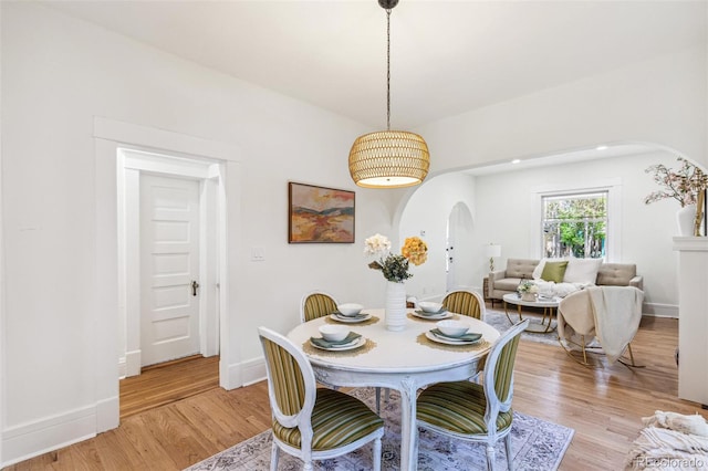 2738 W 38th Ave, Denver, CO 80211 - dining space featuring arched walkways, light wood-style flooring, and baseboards