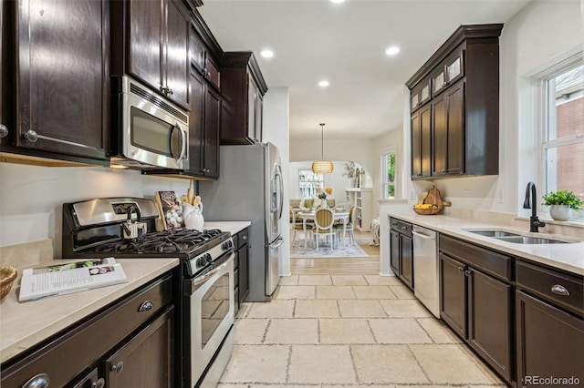 2738 W 38th Ave, Denver, CO 80211 - kitchen with stainless steel appliances, a sink, dark brown cabinetry, light countertops, and recessed lighting