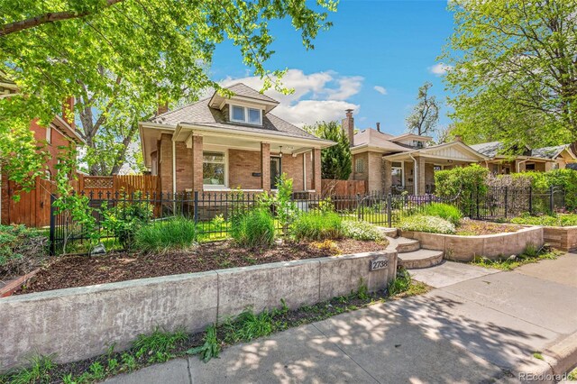 2738 W 38th Ave, Denver, CO 80211 - bungalow featuring a porch, brick siding, a shingled roof, and a fenced front yard