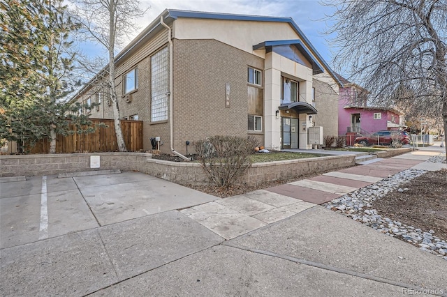 view of front of home with brick siding and fence