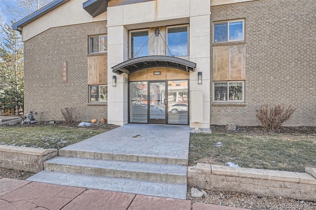 doorway to property featuring french doors and brick siding