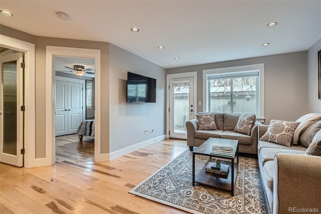 living area with baseboards, recessed lighting, and light wood-style floors