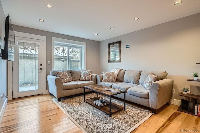 living area with light wood-type flooring, baseboards, and recessed lighting