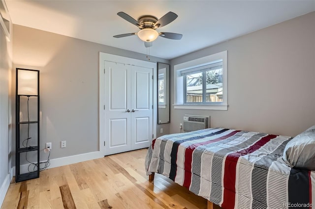 2460 W Caithness Pl Unit 104, Denver, CO 80211 - bedroom featuring light wood-style floors, a wall unit AC, a closet, and a ceiling fan