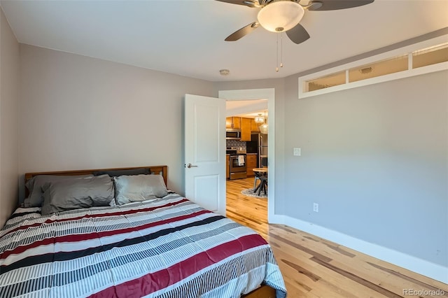 bedroom with a ceiling fan, baseboards, and wood finished floors