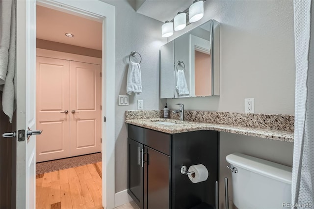 bathroom with vanity, toilet, and wood finished floors