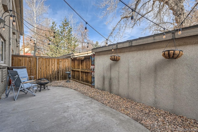 view of patio with an outdoor fire pit and fence