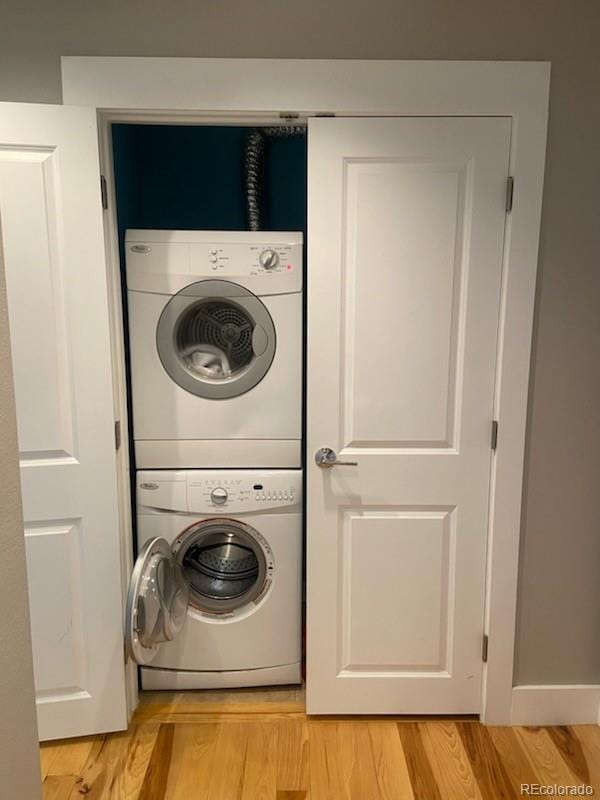 washroom with laundry area, light wood-style floors, and stacked washer and clothes dryer