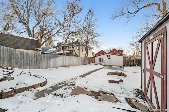 yard covered in snow with a shed