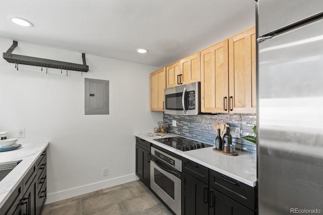 kitchen featuring tasteful backsplash, light countertops, appliances with stainless steel finishes, light brown cabinets, and electric panel