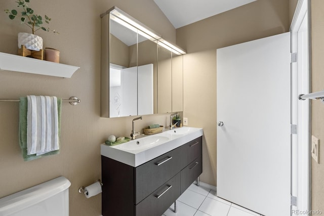 bathroom featuring double vanity, tile patterned flooring, a sink, and toilet