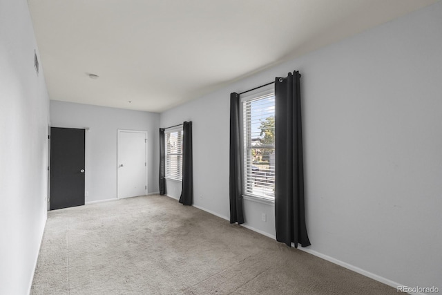 carpeted spare room featuring baseboards