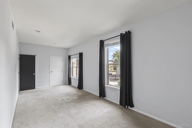 carpeted empty room with baseboards and visible vents