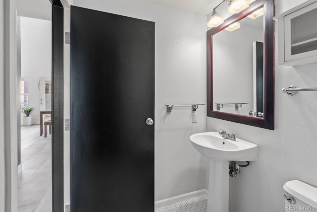 bathroom featuring toilet, baseboards, and tile patterned floors