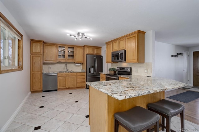6280 Quay St, Arvada, CO 80003 - kitchen with appliances with stainless steel finishes, a sink, tasteful backsplash, a peninsula, and a kitchen breakfast bar