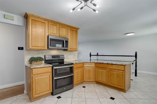 6280 Quay St, Arvada, CO 80003 - kitchen featuring stainless steel appliances, baseboards, tasteful backsplash, and a peninsula