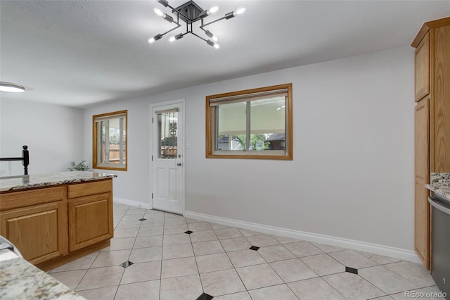 6280 Quay St, Arvada, CO 80003 - kitchen featuring healthy amount of natural light, a chandelier, light stone countertops, and baseboards