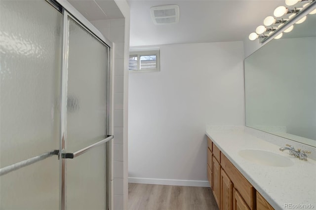 6280 Quay St, Arvada, CO 80003 - bathroom with wood finished floors, an enclosed shower, baseboards, and vanity