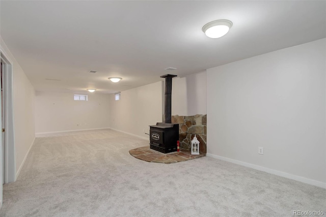 6280 Quay St, Arvada, CO 80003 - below grade area with carpet floors, a wood stove, and baseboards