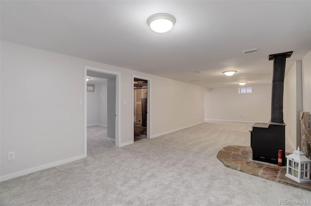 6280 Quay St, Arvada, CO 80003 - finished below grade area with a wood stove, light carpet, and baseboards