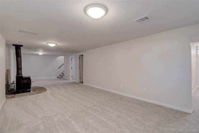 6280 Quay St, Arvada, CO 80003 - below grade area with carpet floors, baseboards, stairs, and a wood stove