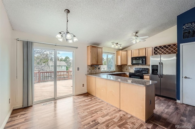 kitchen featuring a peninsula, a sink, light brown cabinetry, a textured ceiling, and black appliances