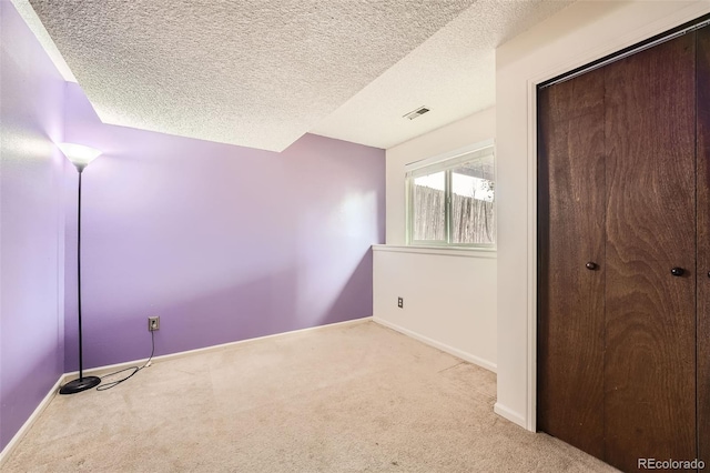 unfurnished bedroom with a closet, visible vents, baseboards, and carpet floors