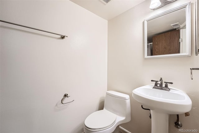 bathroom with a sink, toilet, and visible vents