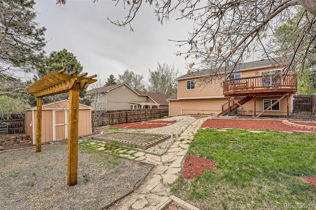 view of yard with a fenced backyard, a deck, an outdoor structure, and a storage shed