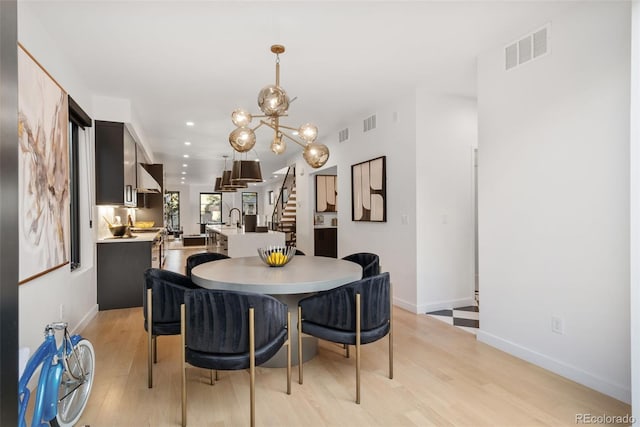 3709 Tejon St, Denver, CO 80211 - dining room featuring light wood-type flooring, a chandelier, recessed lighting, and stairway