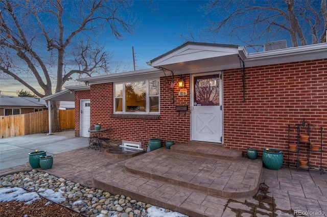 exterior entry at dusk featuring a patio area