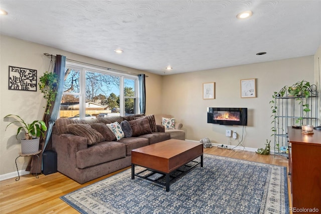 living room with light hardwood / wood-style flooring and a textured ceiling