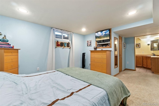 carpeted bedroom with sink and connected bathroom