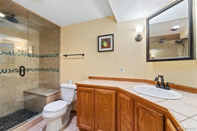 bathroom featuring tile patterned floors, toilet, a shower with shower door, and vanity