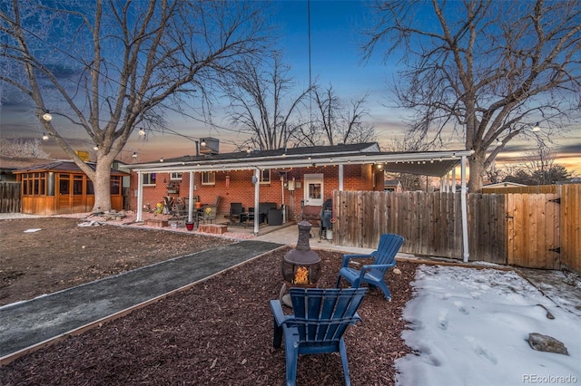 snow covered rear of property with a patio