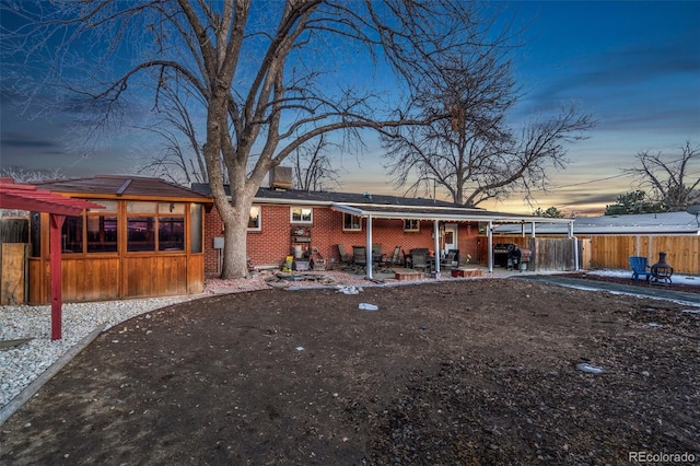 back house at dusk with a patio area